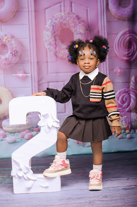 A young child smiling in a playful birthday portrait set