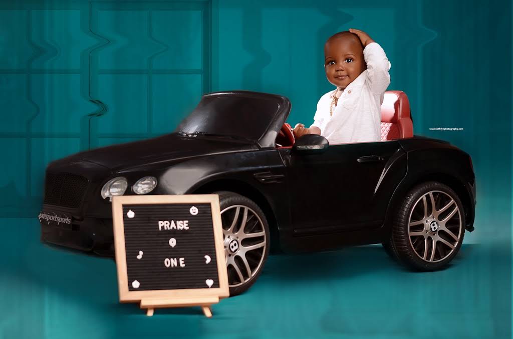 A child photographed in a toy car during a birthday portrait session